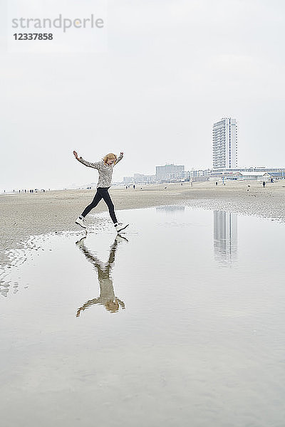 Netherlands  Zandvoort  young woman having fun on the beach