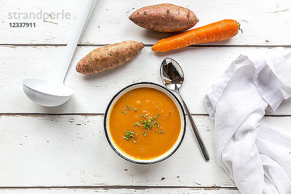 Bowl of sweet potato carrot soup garnished with cress