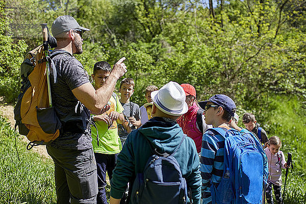 Man talking to kids on a field trip on trail