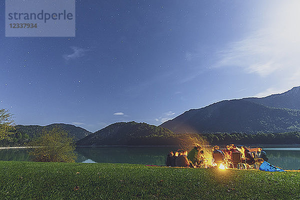 Germany  Bavaria  Sylvenstein Dam  Group of people at camp fire during night