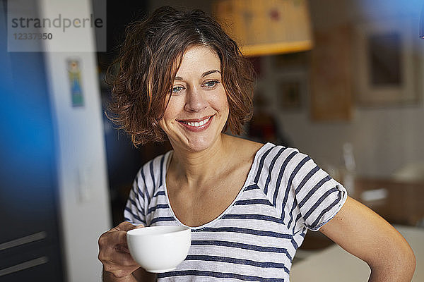 Portrait of relaxed mature woman with cup of coffee at home