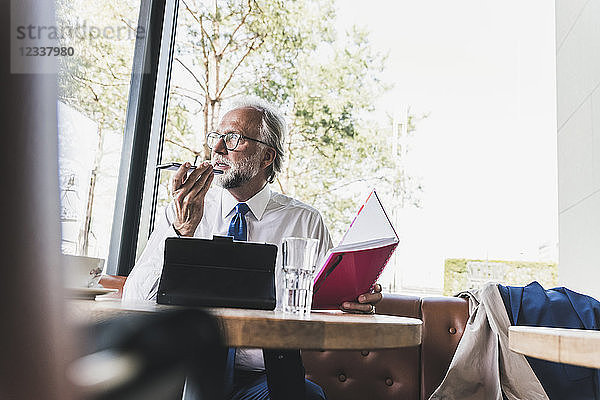 Mature businessman working at table in a cafe