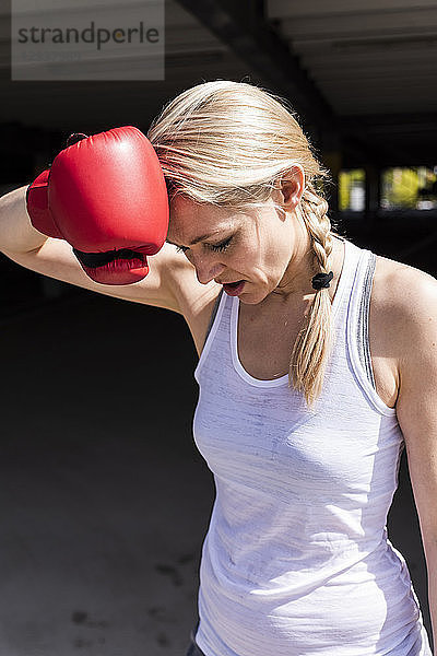 Woman with boxing gloves looking tired