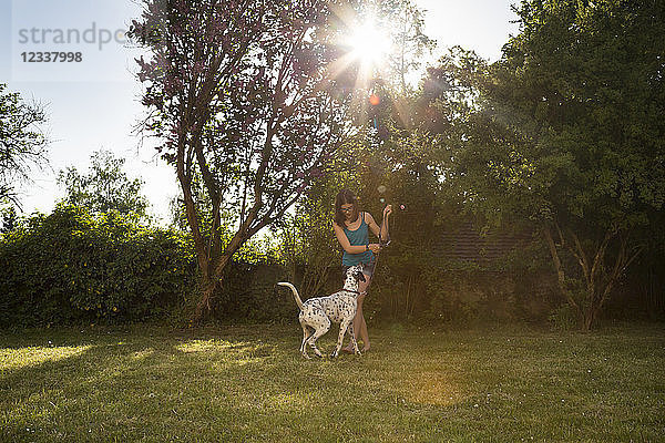 Girl teaching Dalmatian in the garden