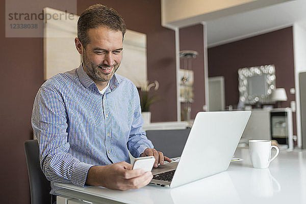 Man sitting at desk  using laptop
