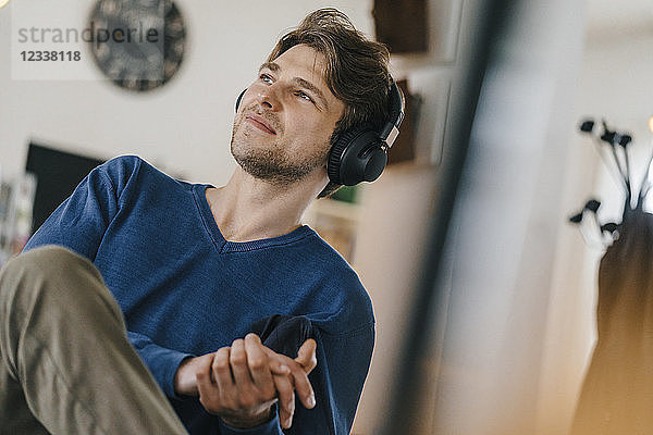 Smiling man in a cafe wearing headphones