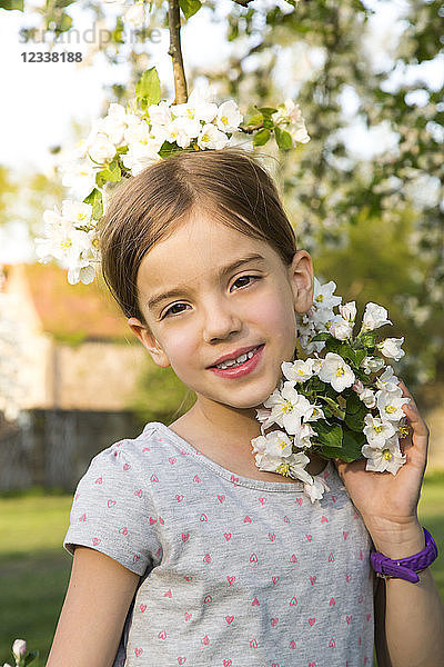 Portrait of smiling little girl with apple blossom