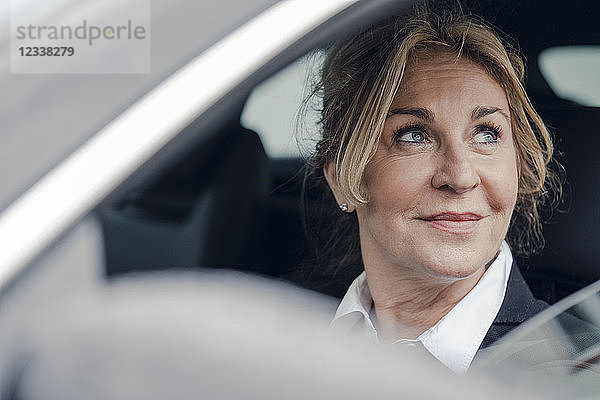 Portrait of smiling senior businesswoman in car