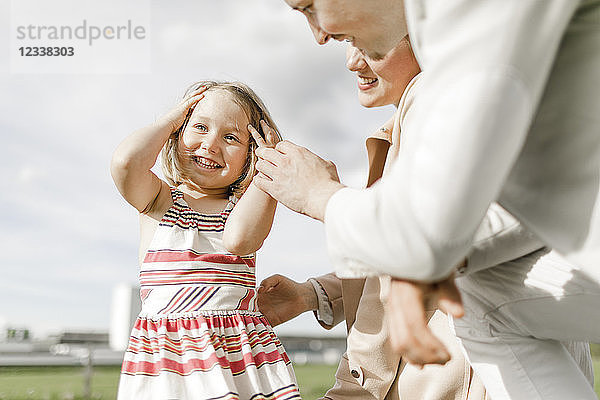 Portrait of happy little girl with her parents outdoors
