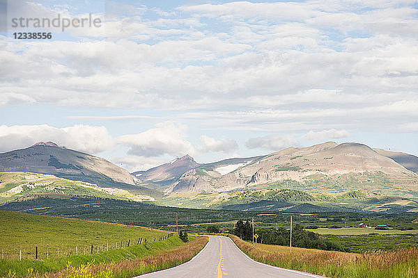 Landschaft mit ländlicher Straße durch ein Bergtal  Browning  Montana  USA