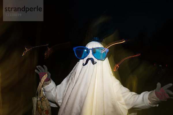 Als Geist verkleidetes Mädchen mit Schnurrbart und übergroßer Sonnenbrille  verschwommen