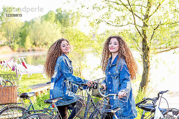 Mode-Blogger-Zwillinge mit Pushbikes am See  Mantua  Lombardei  Italien