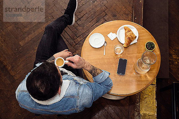 Mann beim Kaffeetrinken im Café