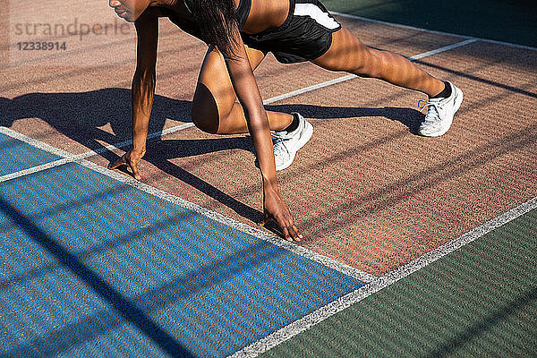 Junge Frau beim Stretching auf dem Sportplatz