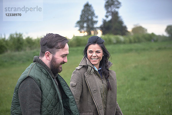 Frau und Mann gehen und lachen auf dem Feld