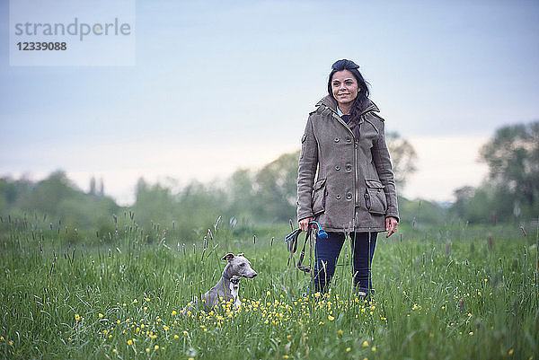 Reife Frau mit ihrem Hund im Feld  Porträt