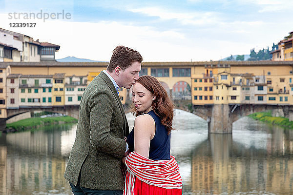 Junger Mann küsst Frau  Ponte Vecchio  die alte Brücke  Florenz  Toskana  Italien