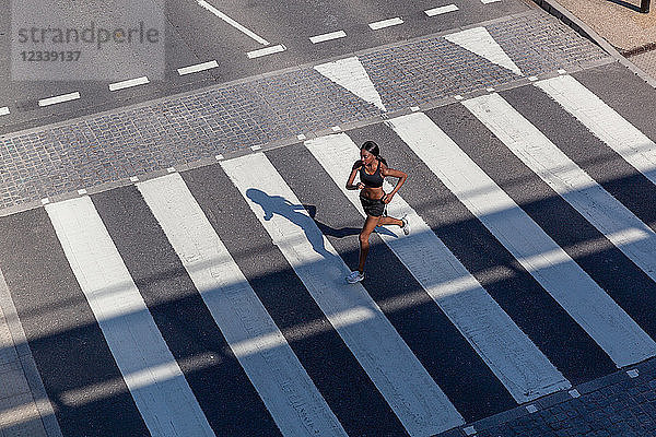 Junge Frau rennt auf Zebrastreifen