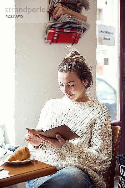 Frau benutzt digitales Tablett im Café