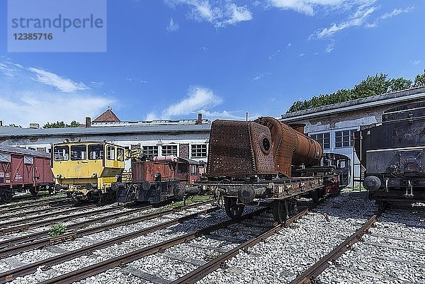 Verschiedene Lokomotiven und ein rostiger Rumpf einer Dampflokomotive vor einem Ringlokschuppen  Bayerisches Eisenbahnmuseum Nördlingen  Nördlingen  Bayern  Deutschland  Europa