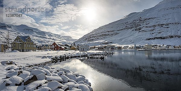 Blick über das Dorf Seyðisfjörður mit Schnee  Spiegelung im See Fjarðará  Austurland  Ostisland  Island  Europa