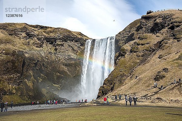 Menschen am Wasserfall Skogafoss mit Regenbogen  Skogar  Südisland  Island  Europa
