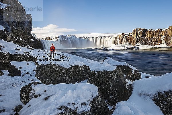 Mann vor dem Wasserfall Góðafoss  Godafoss im Winter mit Schnee und Eis  Skjálfandafljót Fluss  Norðurland vestra  Nordisland  Island  Europa