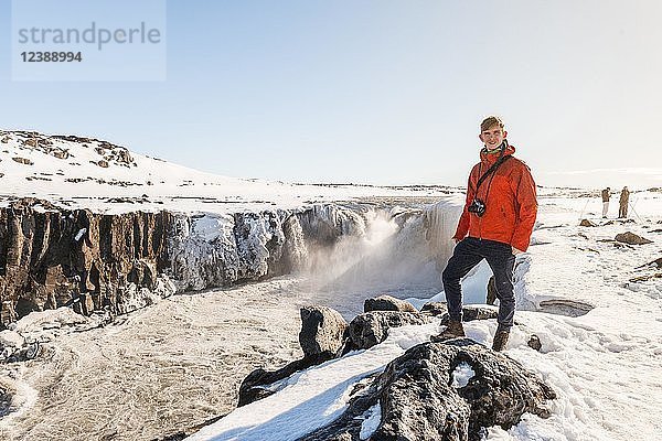 Mann mit Kamera am Rand  Selfoss-Wasserfall im Winter  Schlucht  Nordisland  Island  Europa