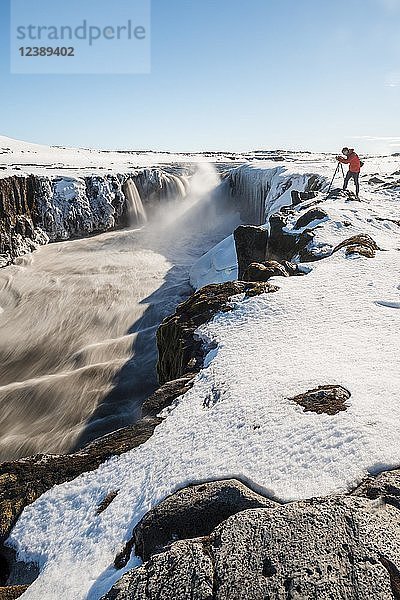 Fotografierender Mann am Rande des Selfoss-Wasserfalls im Winter  Schlucht  Nordisland  Island  Europa