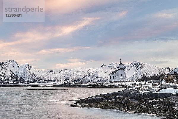 Kirche von Gimsøy umgeben von schneebedeckten Bergen und der Küste  Gimsoykirke  Gimsoy  Lofoten  Norwegen  Europa