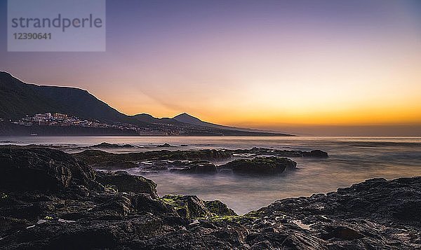 Felsenküste und Meer bei Sonnenuntergang  hinter Bajamar und Vulkan Pico del Teide  Punta del Hidalgo  Teneriffa  Kanarische Inseln  Spanien  Europa