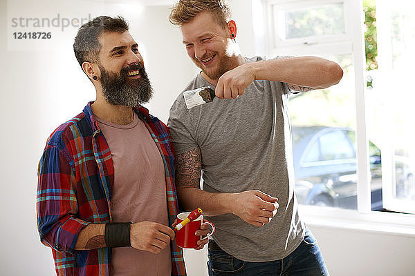 Happy male gay couple painting