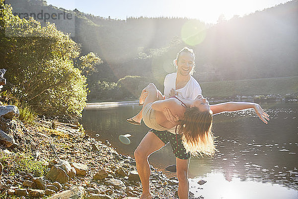 Playful couple at sunny summer lake