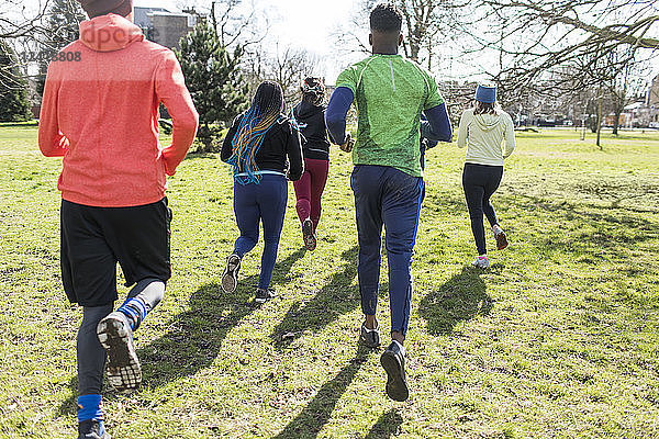 Runners running in sunny park