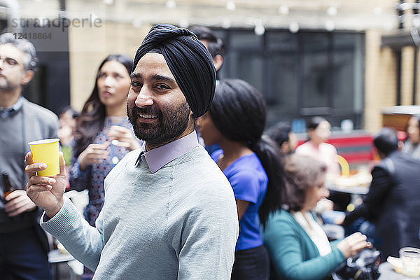 Portrait confident man in turban enjoying party on patio