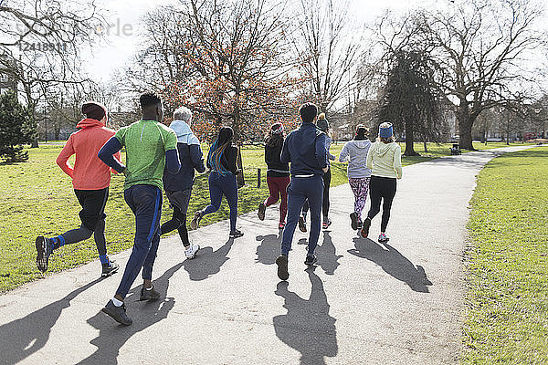 Runners running in sunny park