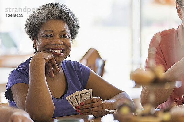 Portrait smiling  confident senior woman playing cards in community center