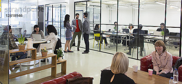 Creative business people talking in open plan office