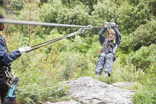 Woman zip lining among trees