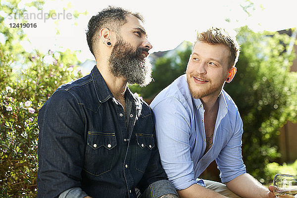 Male gay couple talking in garden