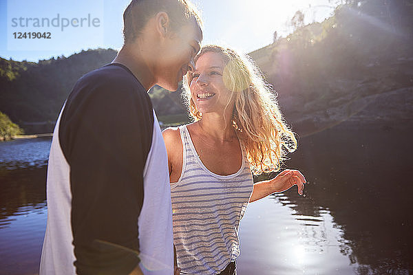 Affectionate  carefree couple at sunny summer lake