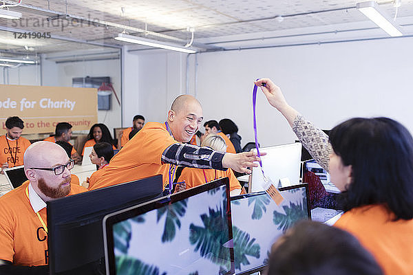 Hackers with lanyard  coding for charity at hackathon