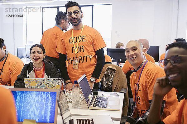 Portrait confident hackers coding for charity at hackathon
