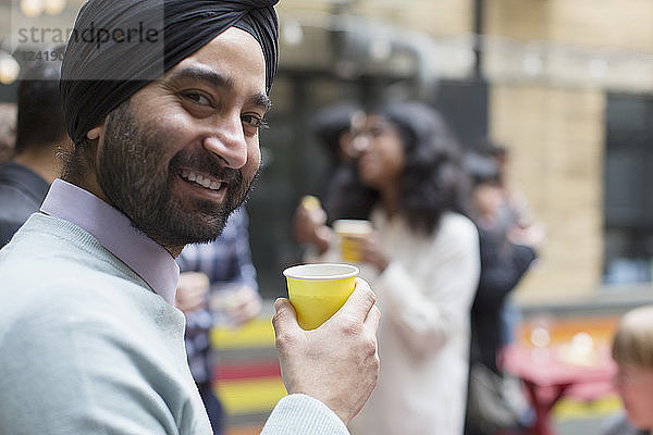 Portrait smiling man in turban drinking  enjoying party