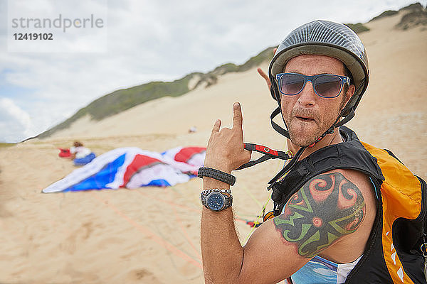 Portrait confident  carefree male paraglider on beach