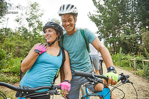 Happy  affectionate young couple mountain biking