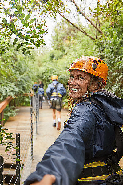 Portrait happy  muddy woman enjoying zip lining