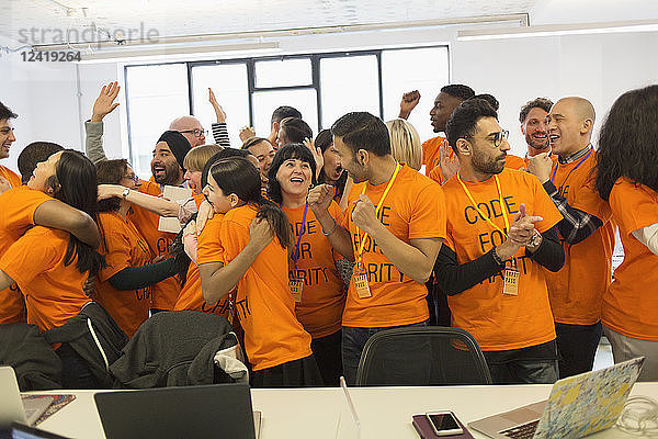 Happy hackers celebrating  coding for charity at hackathon