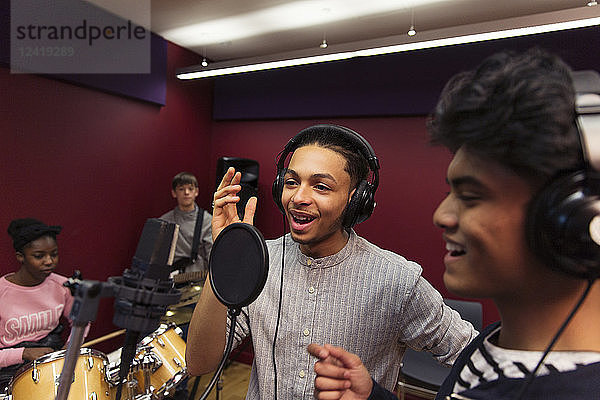 Teenage musicians recording music in sound booth