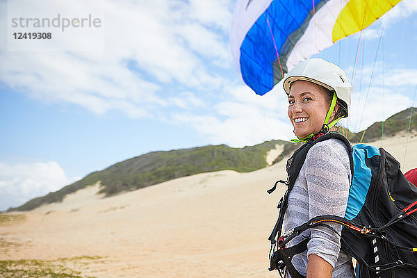 Portrait smiling  confident young female paraglider on beach